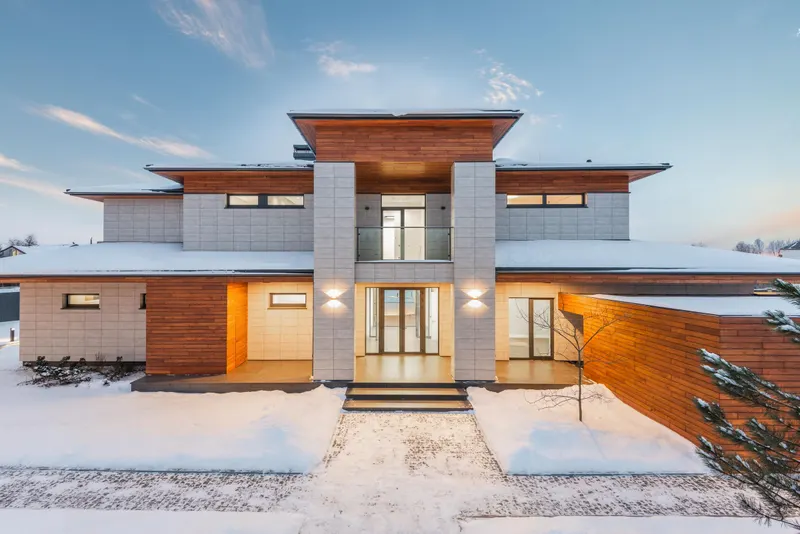 Modern luxury residence with stone and wood facade at dusk